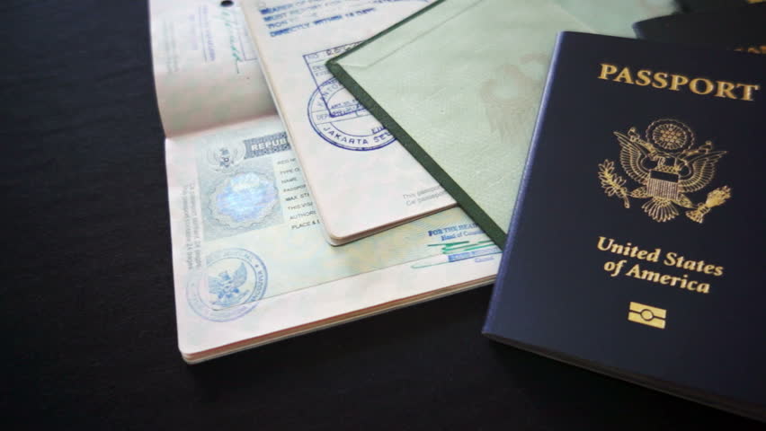 Panning shot of passports from USA, Mexico, Canada and Germany with visa and entry or departure stamps.