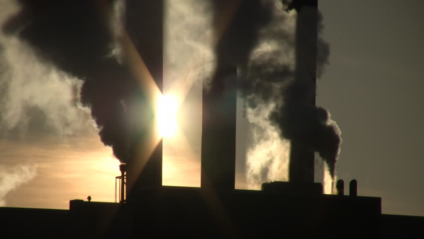 Fumes billow out of a giant smoke stack against the sunny sky (High Definition)