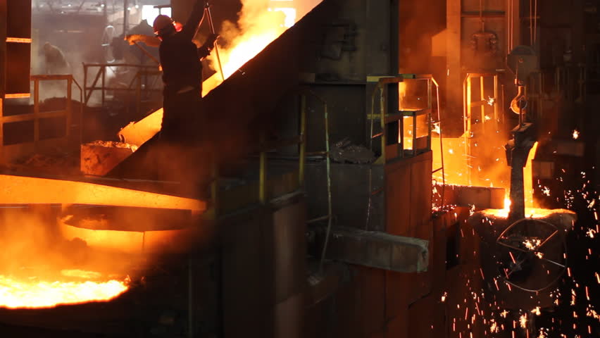 Hard work in the foundry, workers controlling iron smelting in furnaces, too hot and smoky working environment