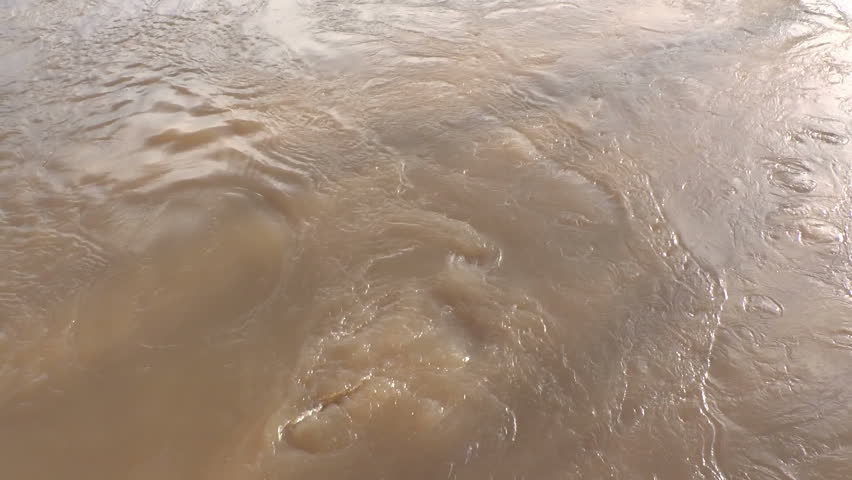 Footage of fast flowing muddy water