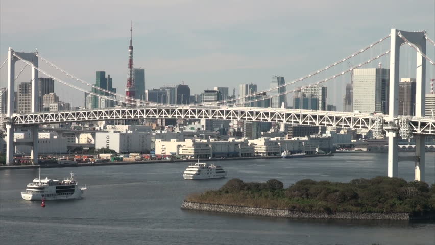 TOKYO, JAPAN - 13 OCTOBER 2012: A cruiseship sails under the massive Rainbow Bridge with the beautiful Tokyo skyline in the background