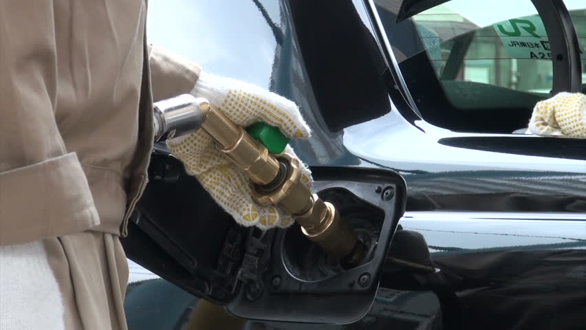 TOKYO, JAPAN - 5 NOVEMBER 2012: Pumping gas (LNG) into a taxi at a gas station in Yokohama, Japan