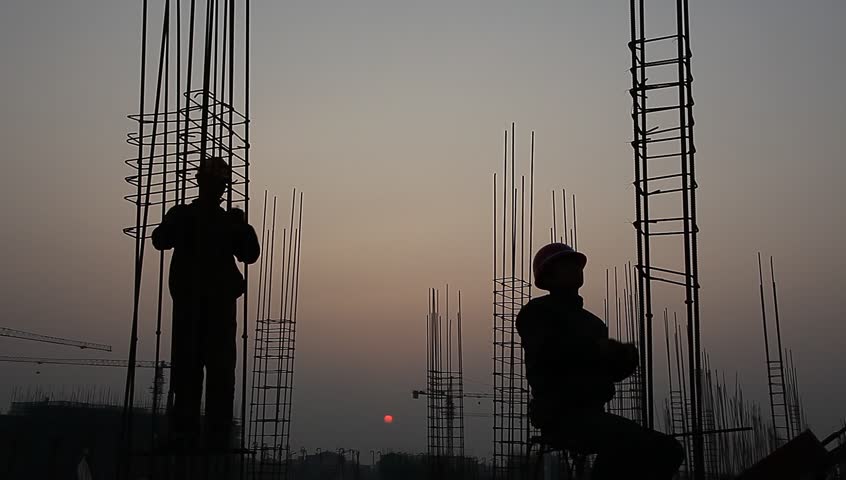 worker working with concrete reinforce iron near sunset