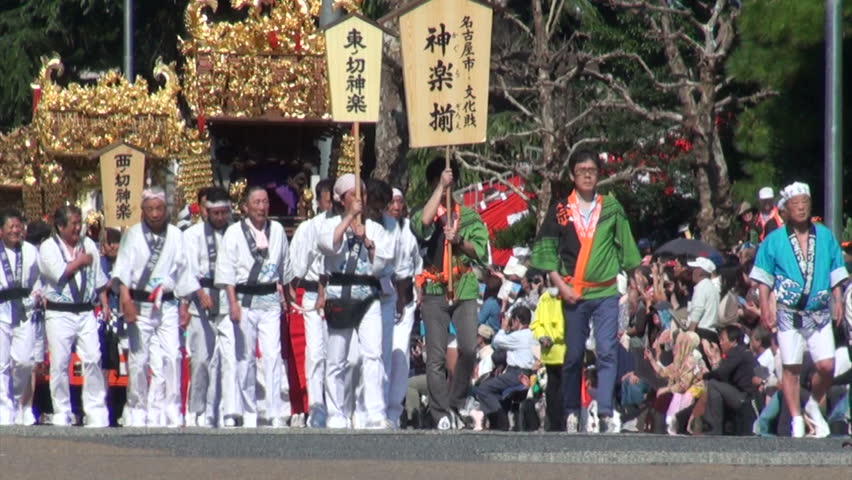 NAGOYA, JAPAN - 21 OCTOBER 2012: People in beautiful traditional Japanese outfits carry golden portable temples through the streets of Nagoya during a festival
