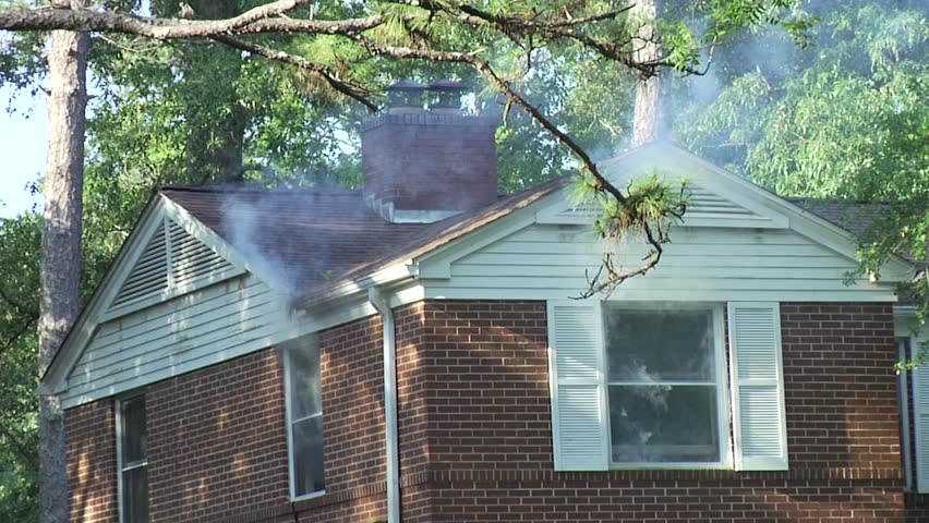 House fire.  Smoke seeping out of the windows.