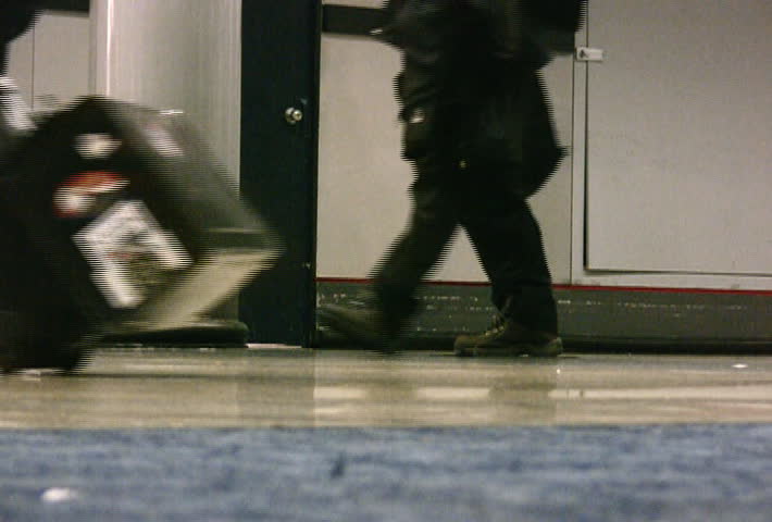 Low angle view showing feet of people moving about in an airport.
