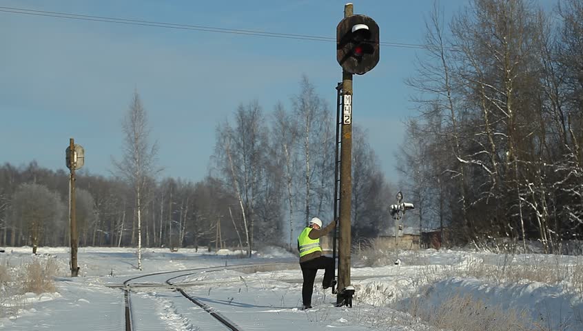 Railroad worker climbing on signal beacons pole