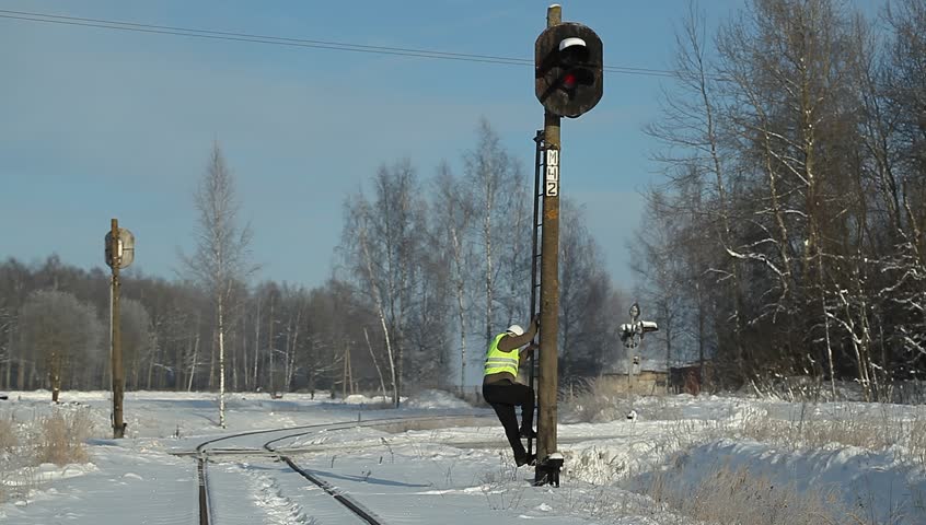 Railroad worker finish checking signal beacons and walking away