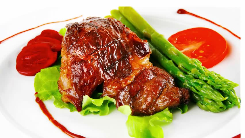roasted beef meat served with asparagus on plate slow motion  hidef