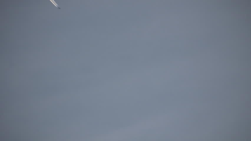 Condensation vapour trails are left behind from a passing airplane.  Also known as contrails, cirrus clouds, or wingtip vortices. (High Definition)