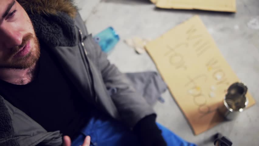 homeless man lighting a cigarette