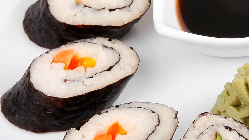 Maki Sushi : Maki Rolls and California rolls made of fresh raw Salmon(sake) Tuna(maguro) and Eel(unagi) . on white dish with sticks hidef slow motion intro