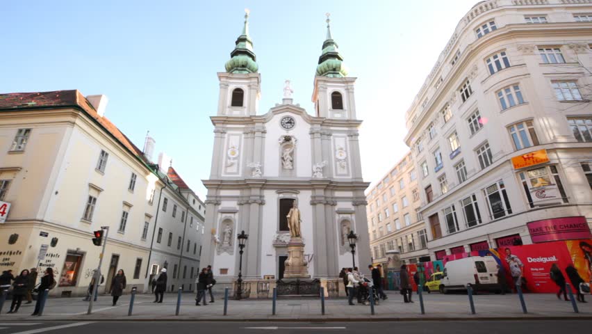 VIENNA - FEB 21: Several people pass by church of Mariahilf, Feb 21 2012, Vienna, Austria. Baroque Church of Mariahilf is parish church and church of Congregation of Saint Michael Archangel in Vienna.
