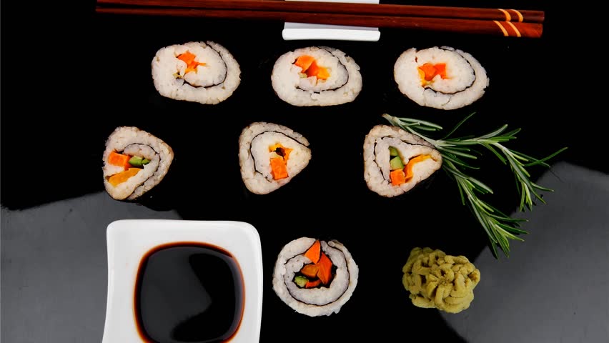 Roll with Cucumber Cream Cheese with raw Tuna and Salmon inside. on black wooden plate. Japanese traditional Cuisine