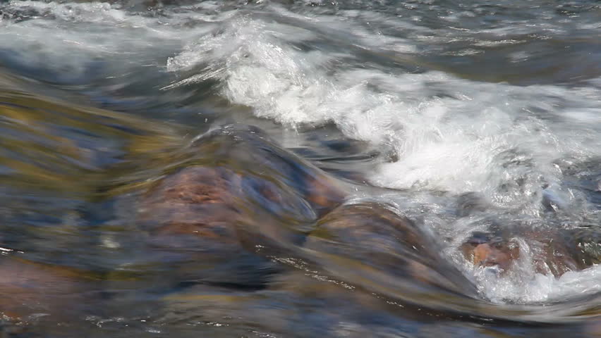 Fast flowing water over rocks of a mountain stream