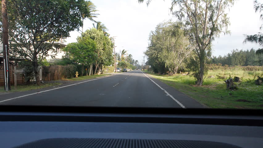 Timelapse video footage shot from a moving vehicle driving around the island of Oahu in Hawaii. The footage shows some of the dashboard of the car and vehicles passing in the street during travel.