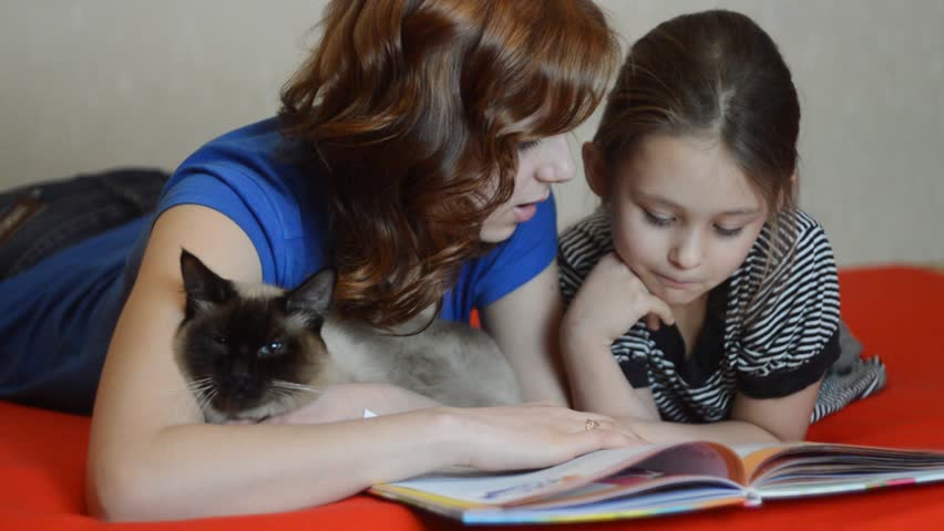 Mother and daughter reading a book with enthusiasm