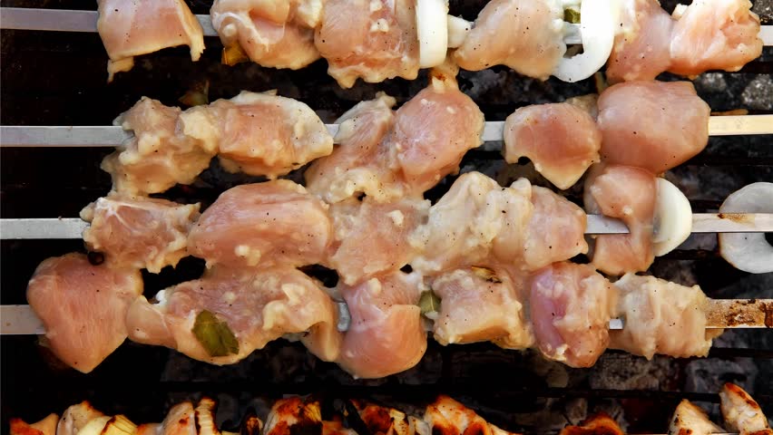 grilled and raw chicken shish kebab cooked on barbecue appliance