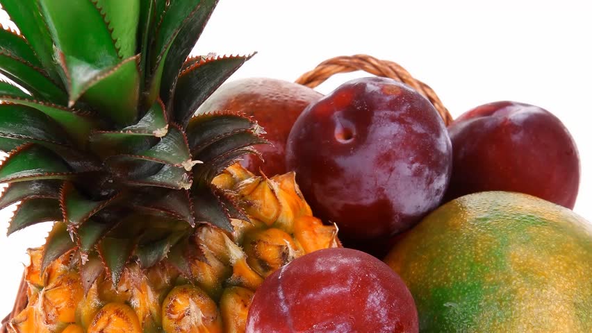 diet food - a lot of fresh raw tropical fruits include pineapple plum and mango in small basket hidef slow motion intro