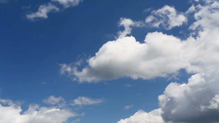 Time lapse clip of white fluffy clouds over blue sky