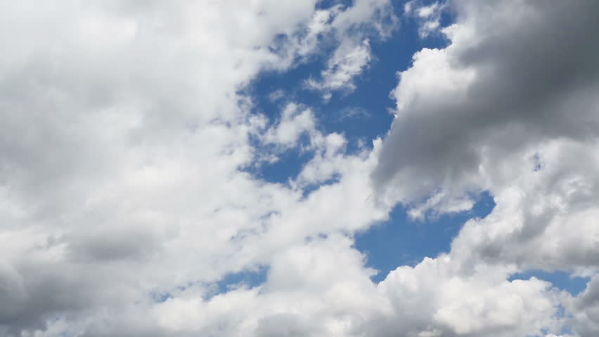 Time lapse clip of white fluffy clouds over blue sky