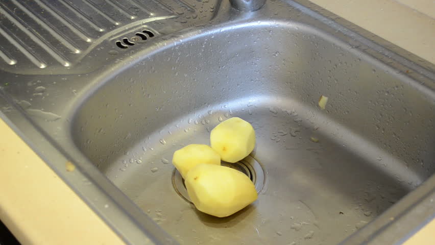 peeled potatoes fall into chromium sink. food prepare.