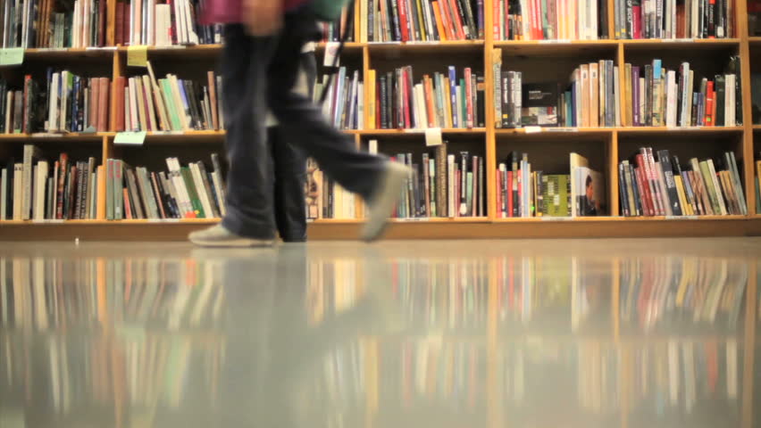 People walking in front of stacks of books
