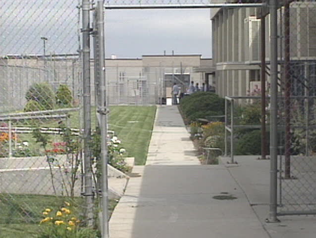 Prisoners walk past camera. 