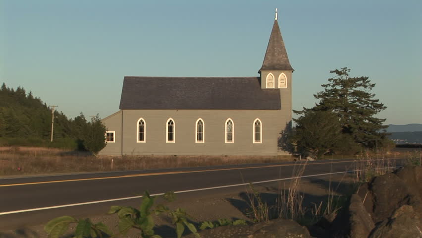 Side view of rural church with passing car