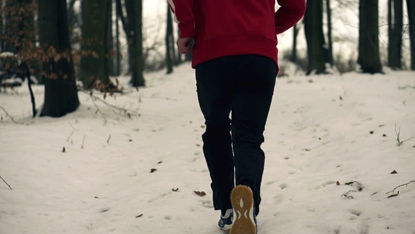 Lone runner in wintry wood, slow motion shot at 120fps
