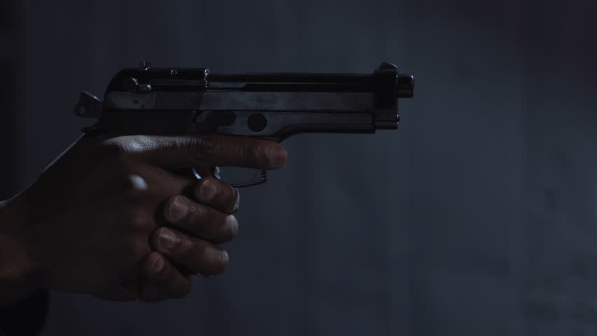 African American man with a 9 mm handgun. Profile