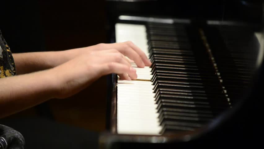 Kid playing nice song on a grand piano during recital (close up) High Definition HD 1080P