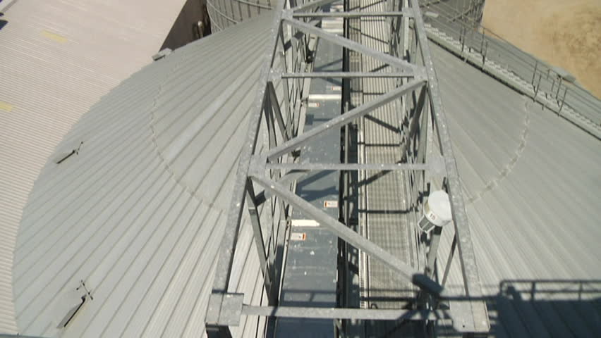 wide tilt upshot of grain elevators with fields in distance