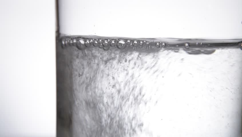 Fizzy pill aspirin is in glass of water.  Close up.