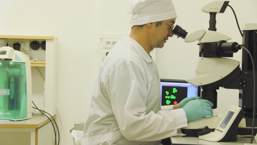 Scientific laboratory, man looking in microscope