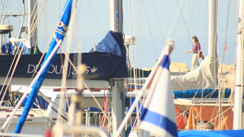 boats anchored at Jaffa port out of focus with two women pass by out of focus