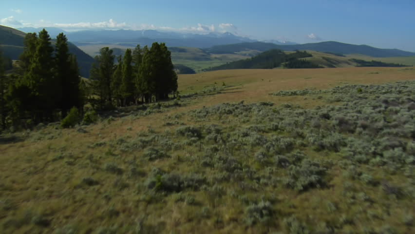 aerial shot of sagebrush pastureland with mountains