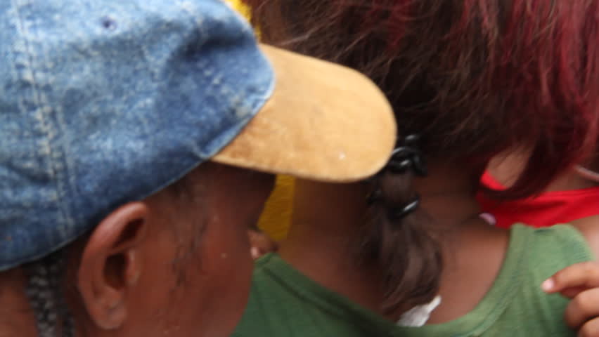 PORT AU PRINCE HAITI - CIRCA MAY 2012:young Haitian children and their parents wait in line at the vaccination clinic