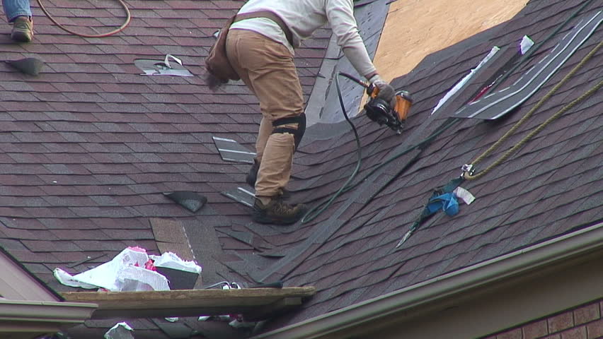 Roofers shingling the roof of a house. HD 1080
