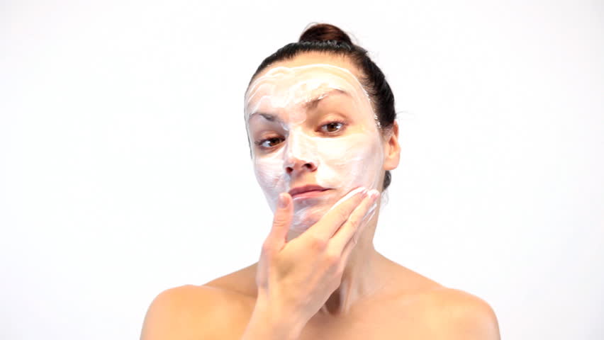 woman doing cosmetic mask on her face
