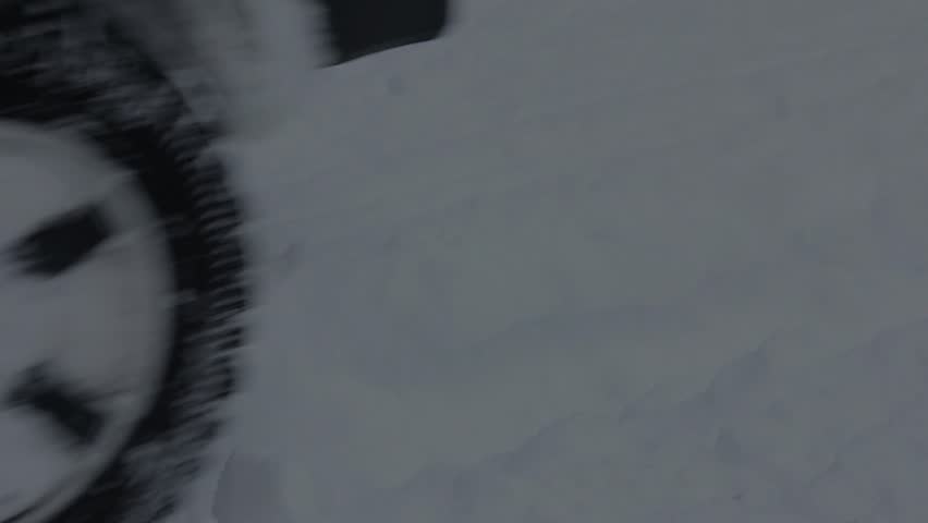 Wheel. car pulling out of a driveway after a snowstorm. 