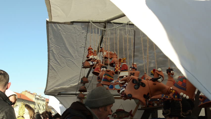 VILNIUS, LITHUANIA - MARCH 02: Different crockery clay handmade cow objects decorations hang in outdoor spring fair market festival tent and customers choose them on March 02, 2012 in Vilnius.