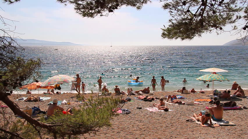 People on the beach, sunbathe and enjoy on vacation. Summertime at Adriatic Sea on the island Brac in Croatia