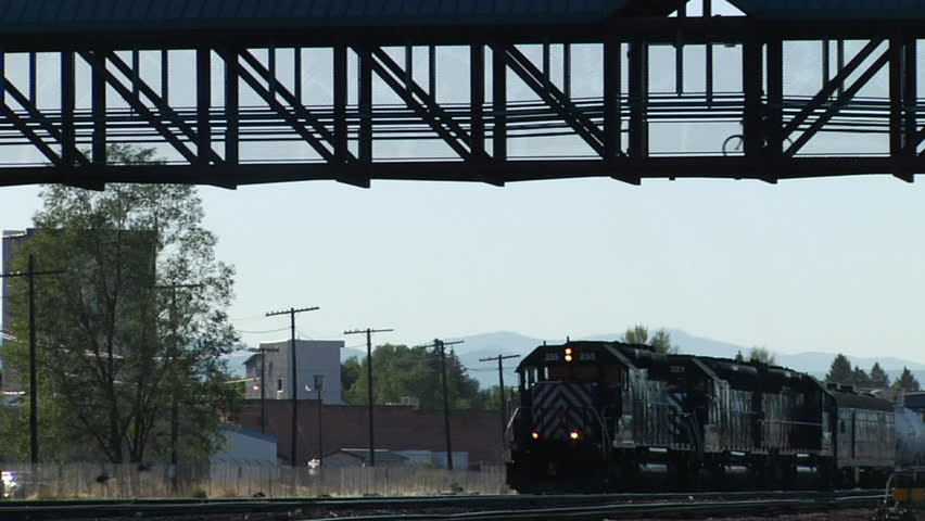 Train passes under a pedestrian/biking bridge