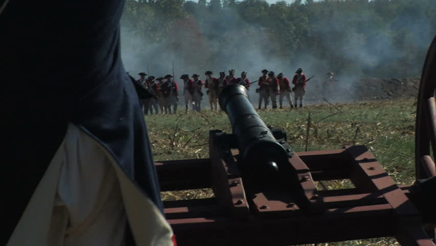 VIRGINIA - OCTOBER 2009 - large-scale, epic American Revolutionary War anniversary reenactment -- in the middle of battle.  Continental Army (or British) cannon crew loads and fires iron cannon