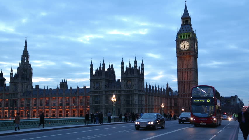 LONDON - MARCH 13: Buses, cars and pedestrians cross Westminster Bridge at night with Houses of Parliament in the background on March 13, 2013 in London. The Palace of Westminster is a UNESCO site.