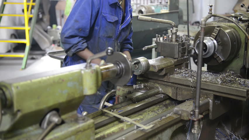 An industrial service repairmen labouring in workshop, selective focus, working on industry machine 
