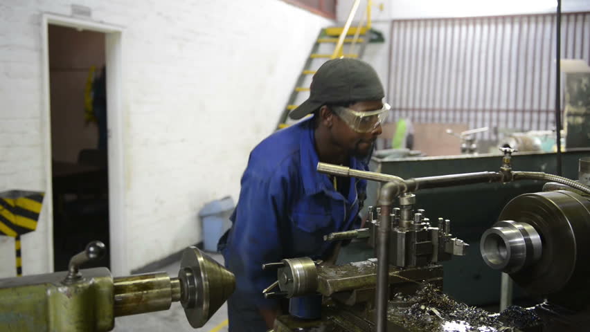 An industrial service repairmen labouring in workshop, selective focus, working on industry machine 