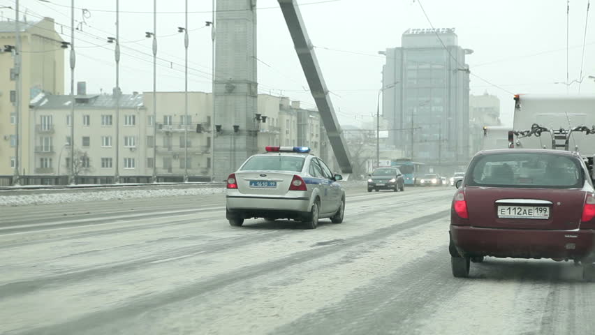 MOSCOW - MAR 24, 2013: Police car with rotating lights driving on Crimean Bridge in Moscow. Vehicle shot. Winter snowy day.