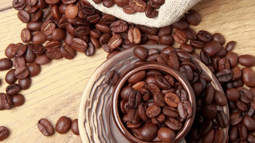Dark brown ceramic cup full of coffee beans